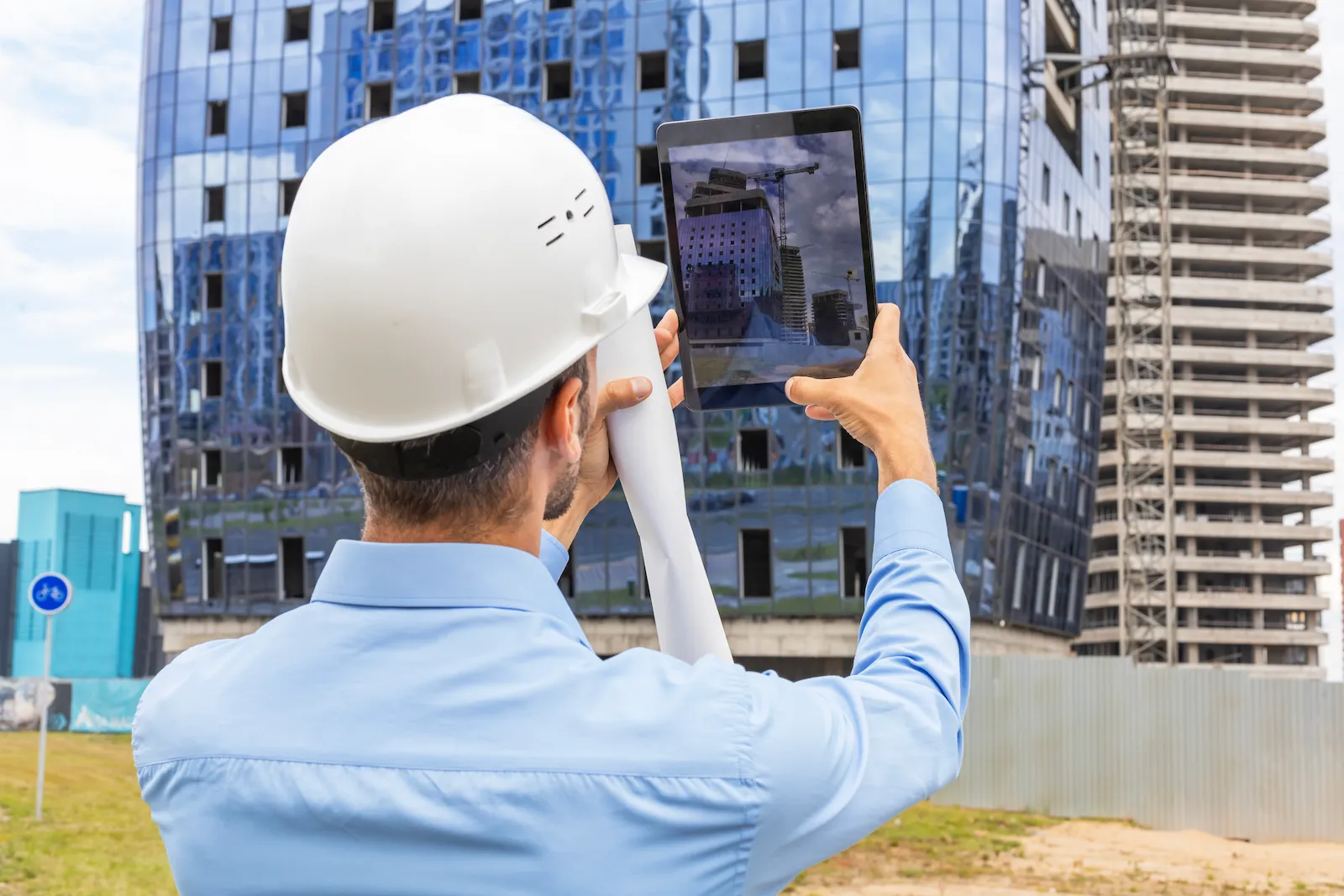 A site supervisor capturing progress on a tablet while walking the construction site