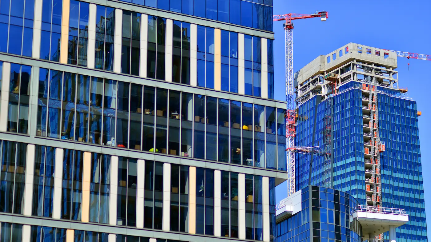 The completed commercial tower, glass facade under an overcast sky