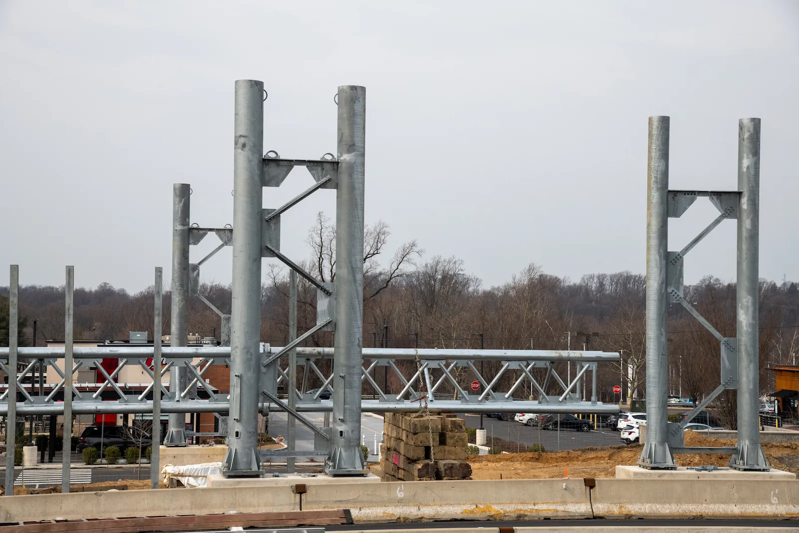 A structural steel frame under construction, beams being erected against an overcast sky