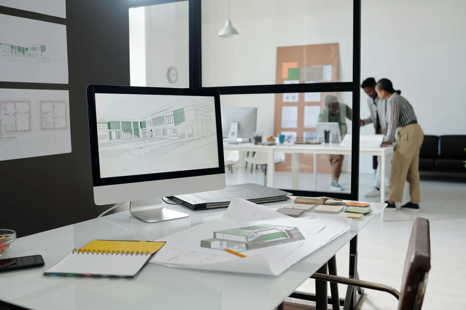 Rows of dual-monitor workstations in a digital engineering operations centre, models and drawings on screen