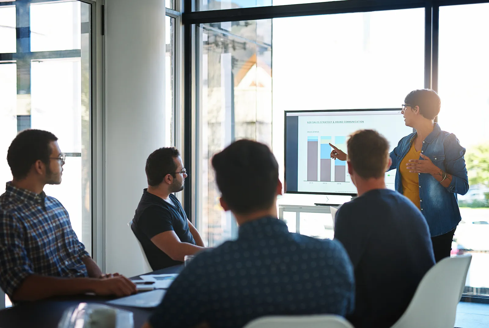 An implementation specialist configuring a project management platform at a dual-monitor desk