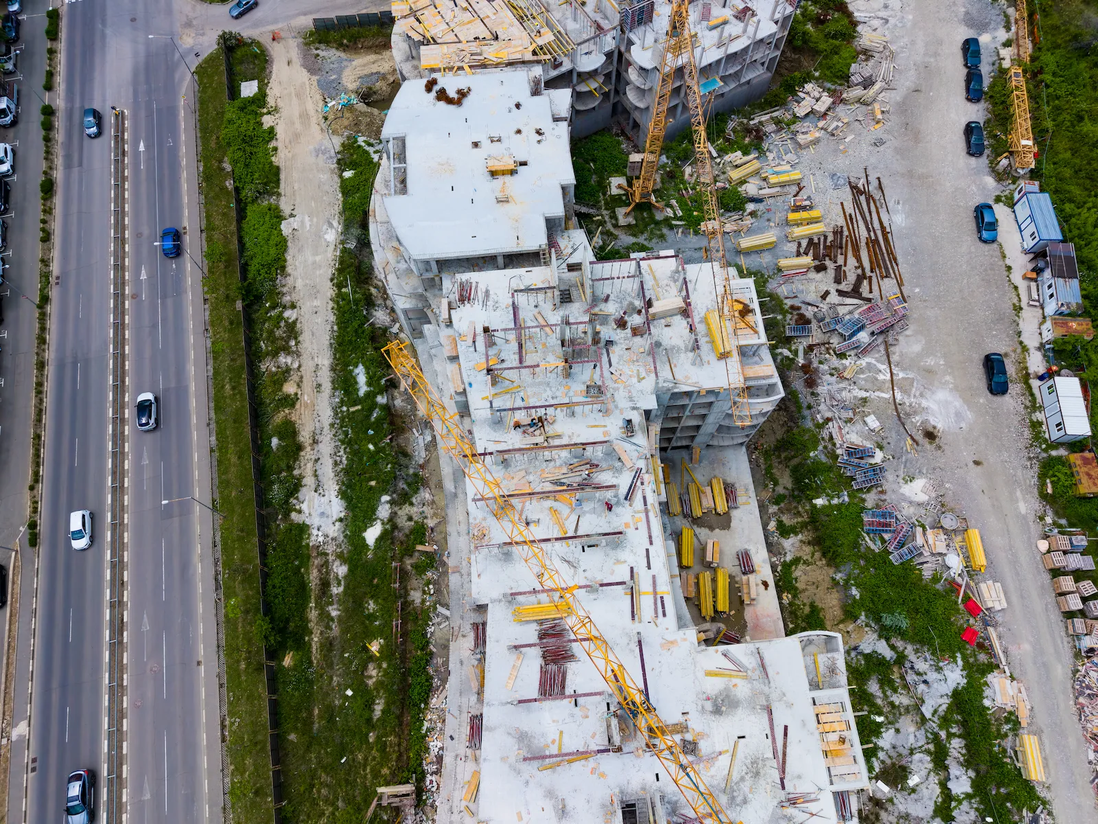 A structural steel frame under construction with a crane lifting a beam into place