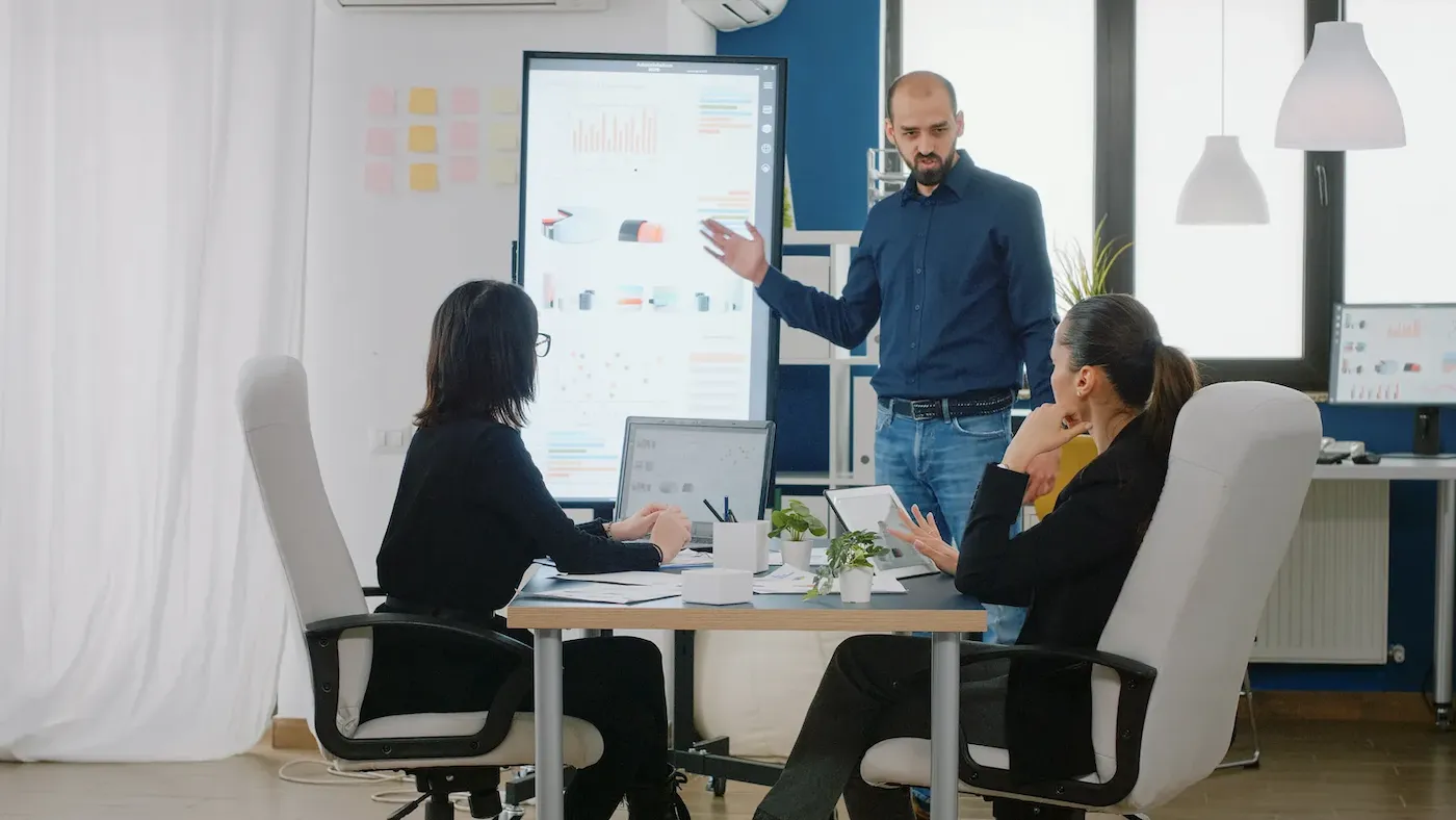 Star-Knowledge Engineering Services consultants collaborating on project analytics and digital planning data during an office presentation.