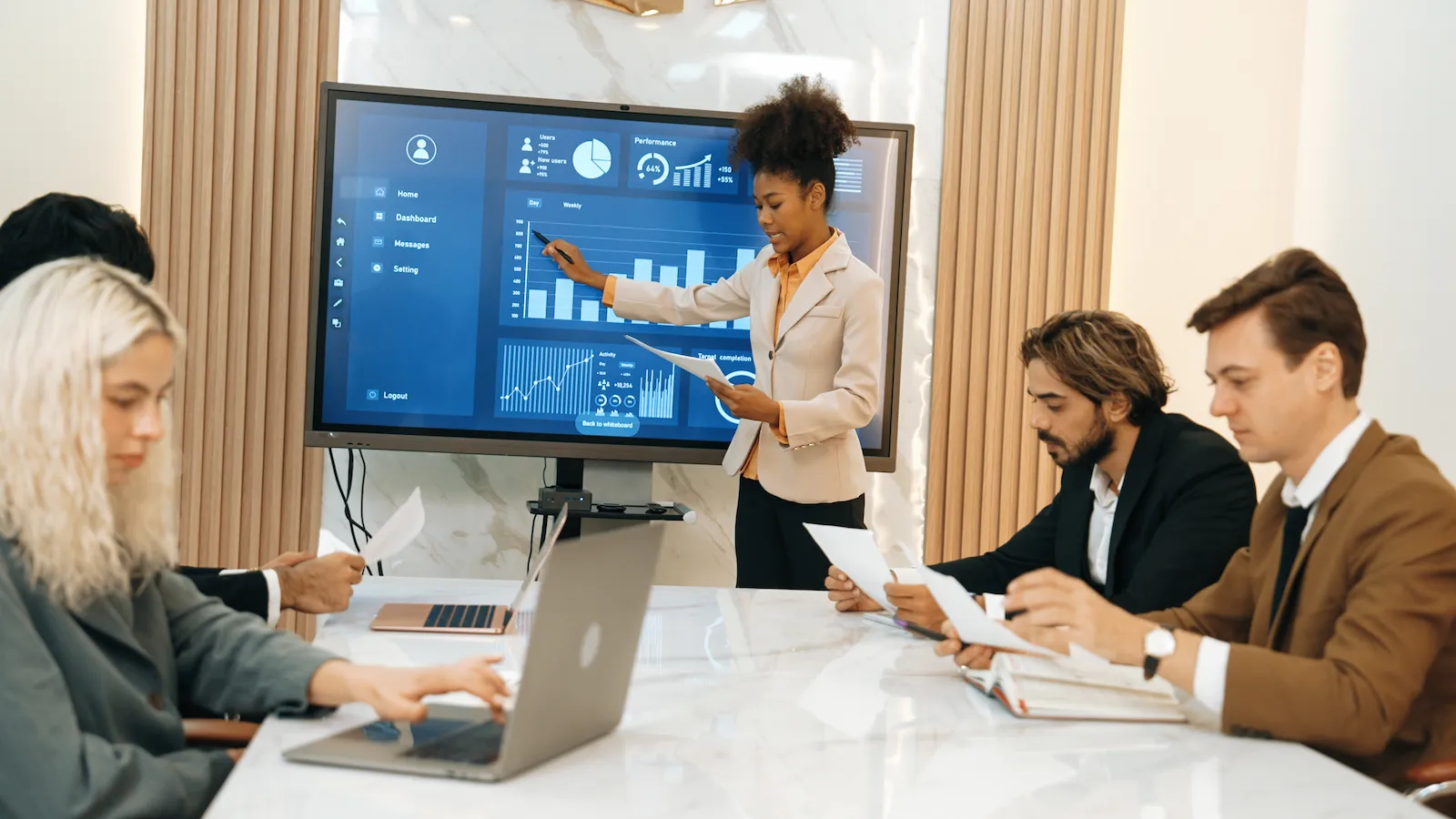 A consultant presenting a software rollout plan to a project team in a meeting room